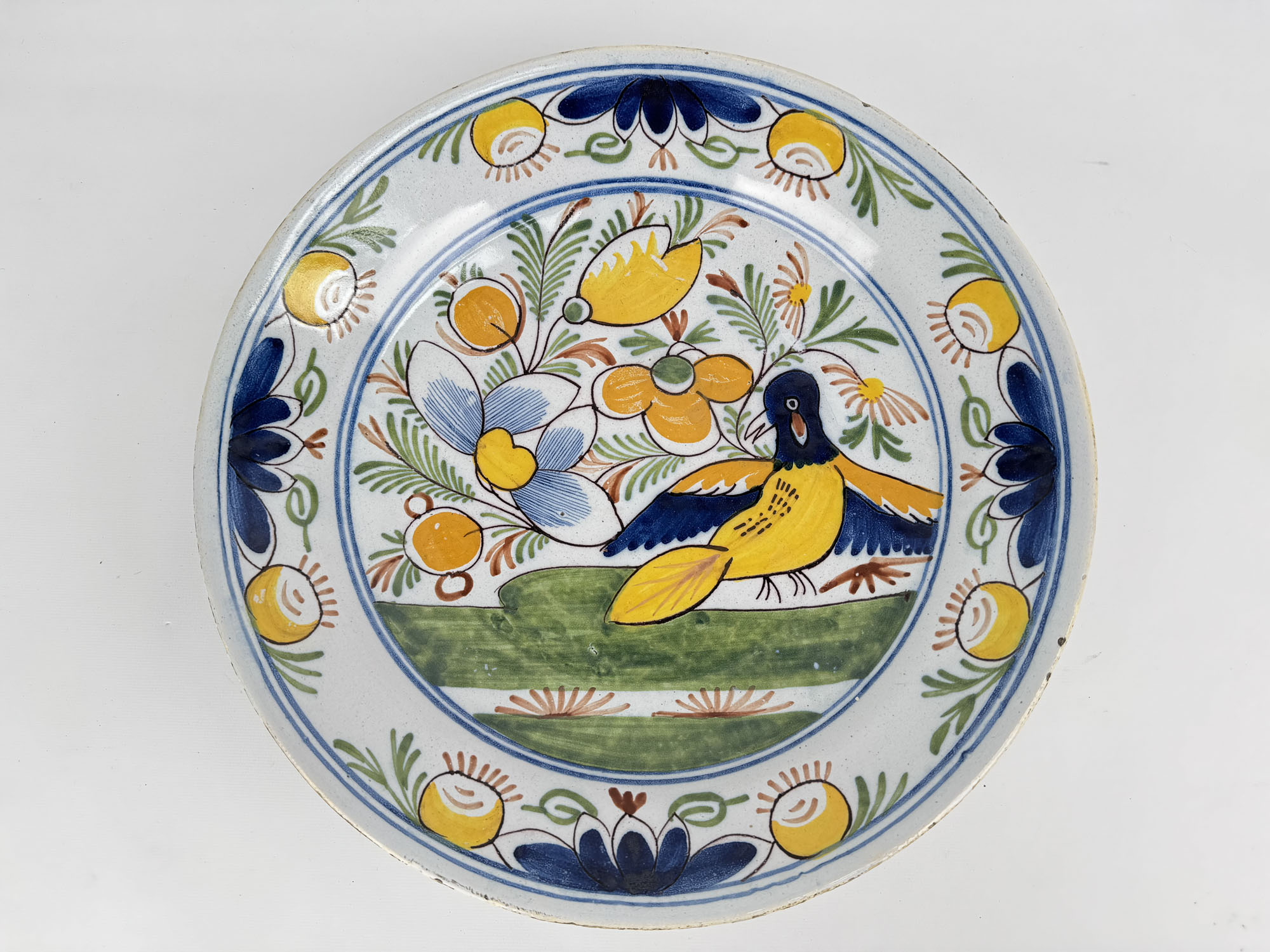 PLAT ROND en faïence émaillée polychrome à décor d’un oiseau…
