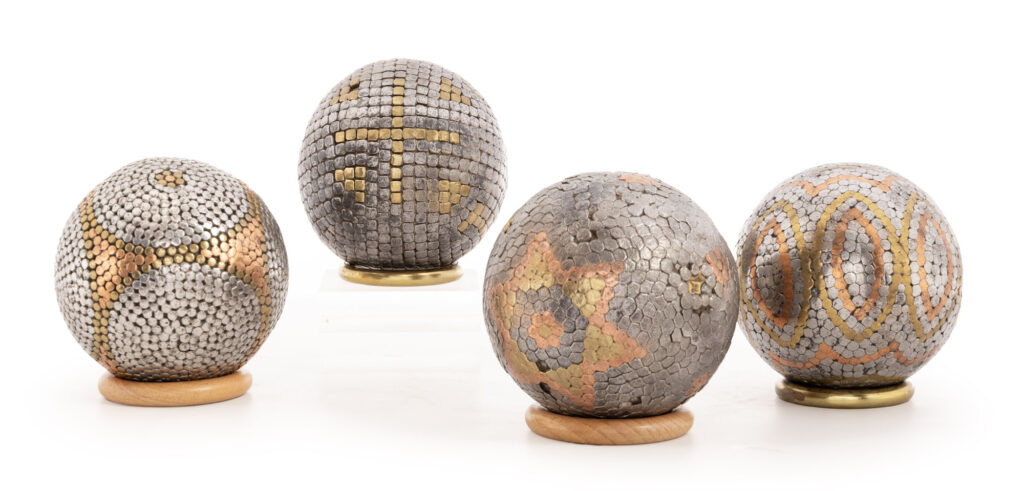 QUATRE BOULES en bois clouté de différents métaux dont cuivre,…