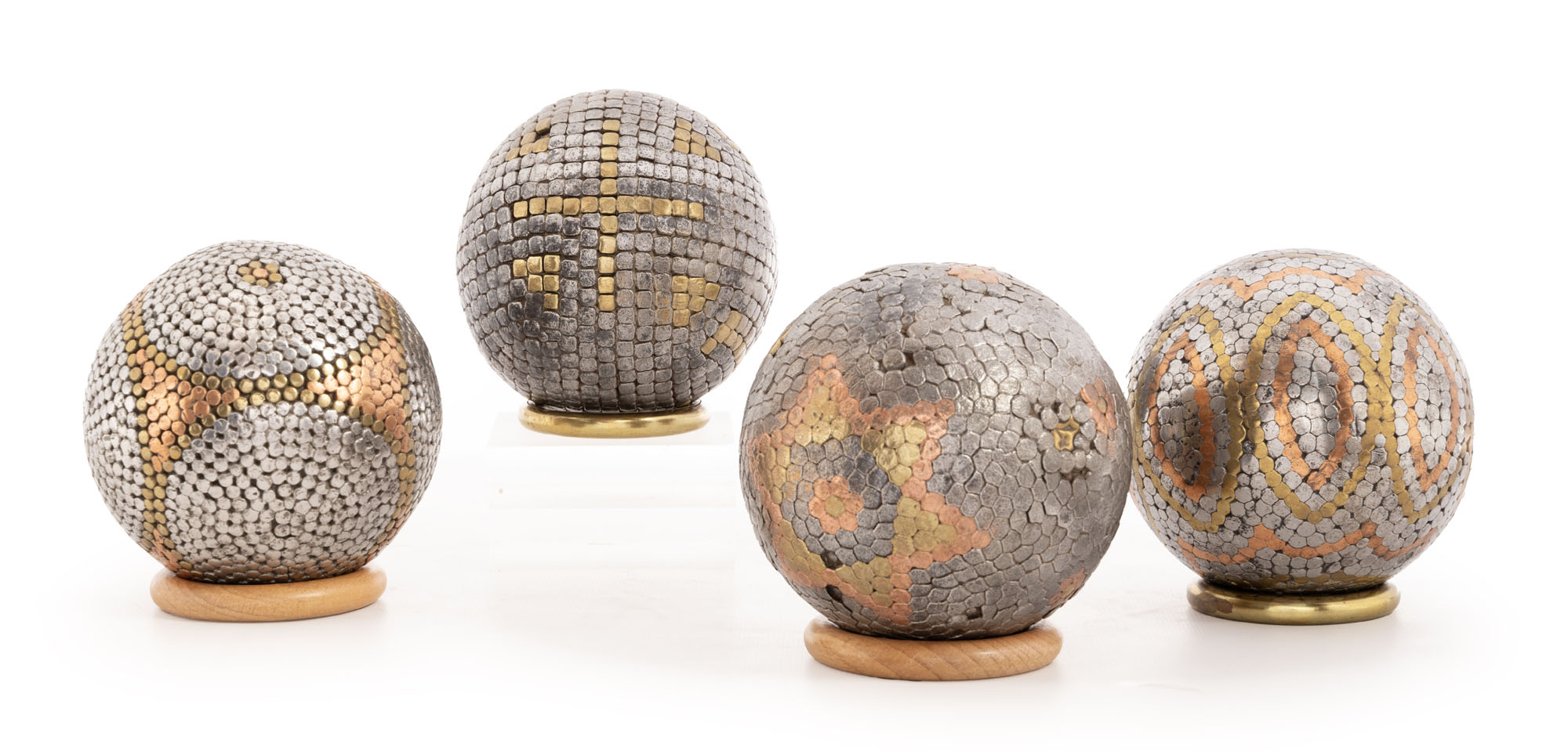 QUATRE BOULES en bois clouté de différents métaux dont cuivre,…