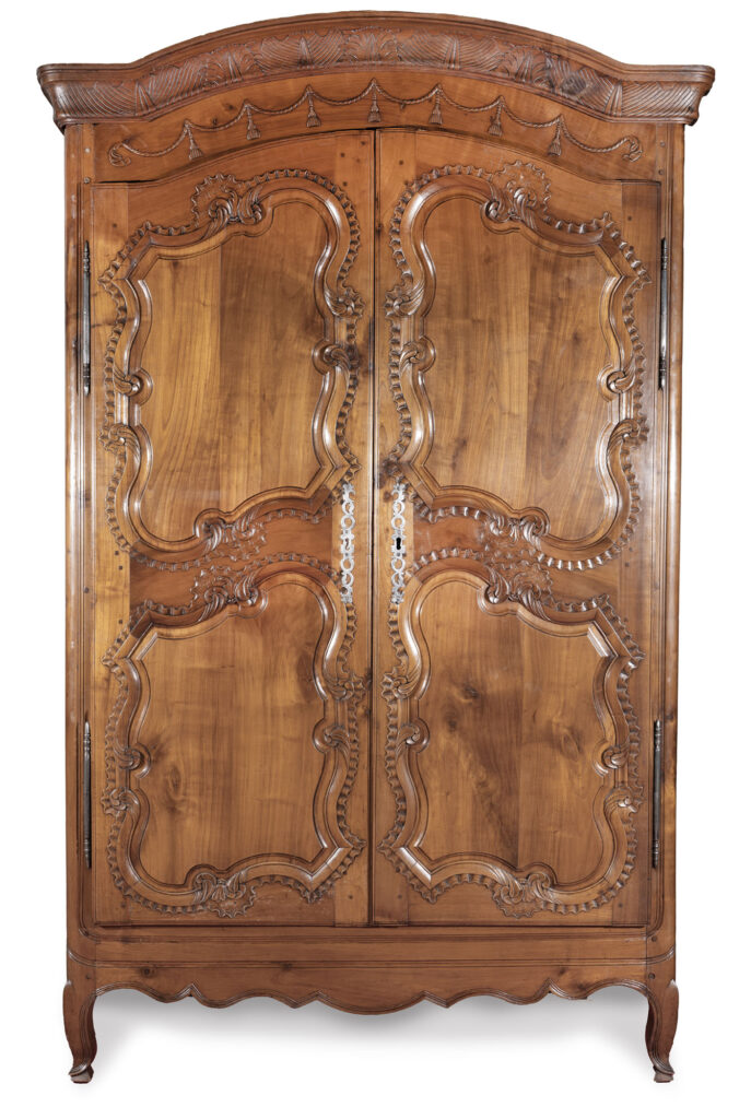 ARMOIRE en merisier sculpté et mouluré, la corniche à décor…