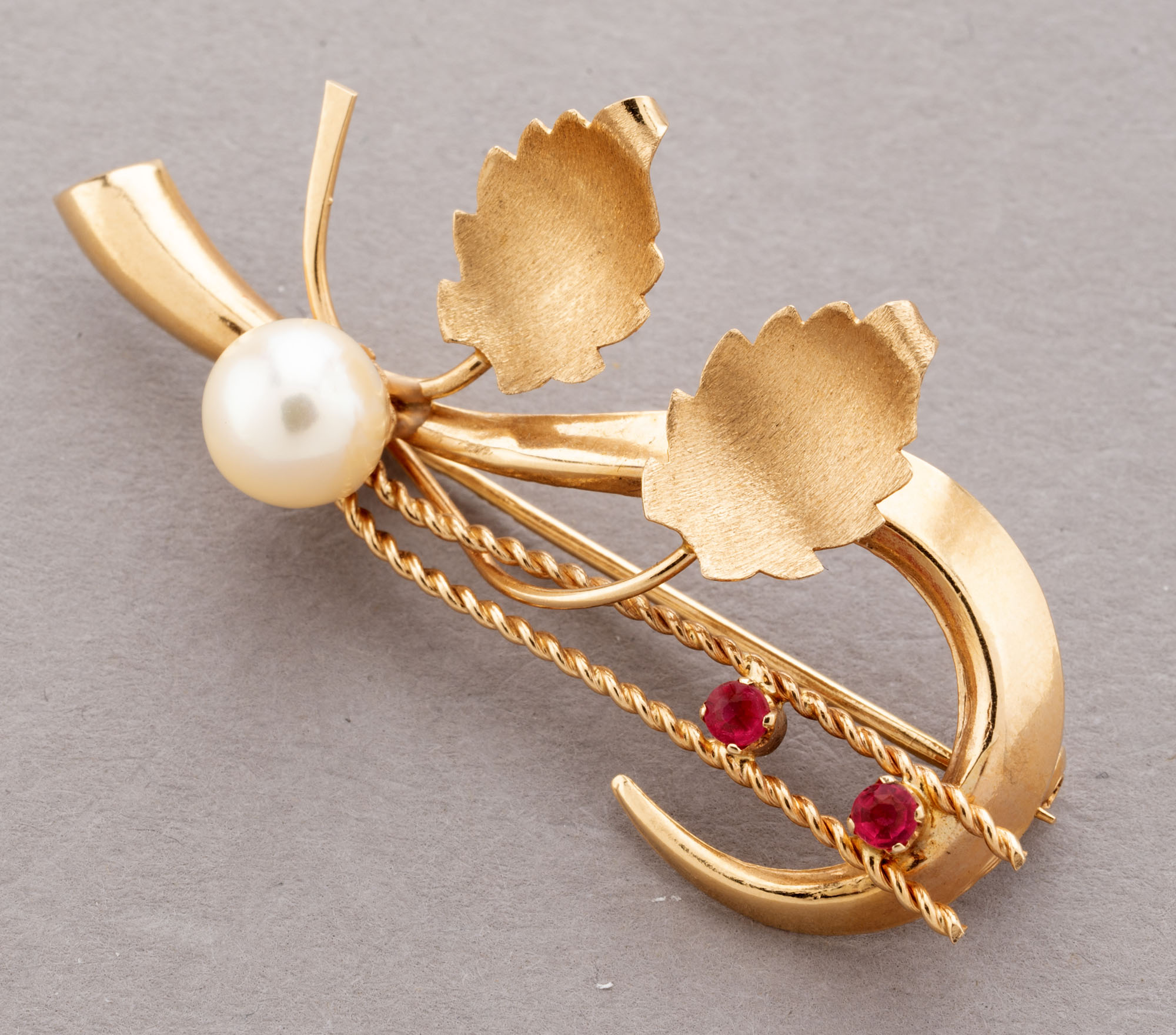 BROCHE en rose 750 millièmes à décor floral stylisé, ornée…